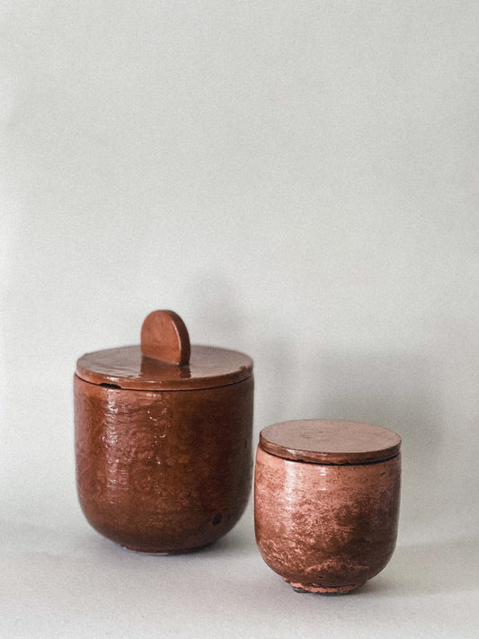 Two concrete candle jars with lids on a light gray background