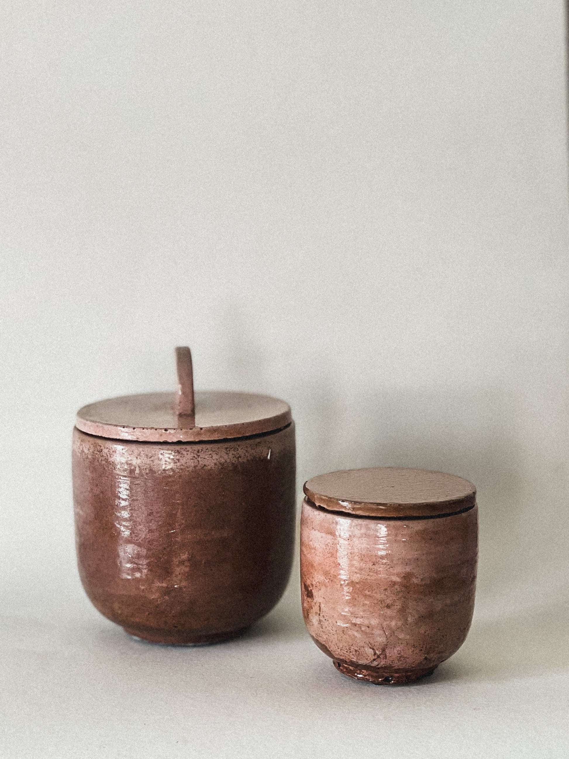 Two concrete candle jars with lids on a light background