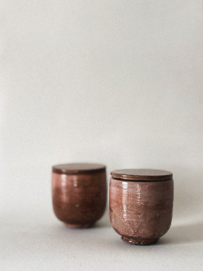 Two mini concrete candle jars on a light gray background