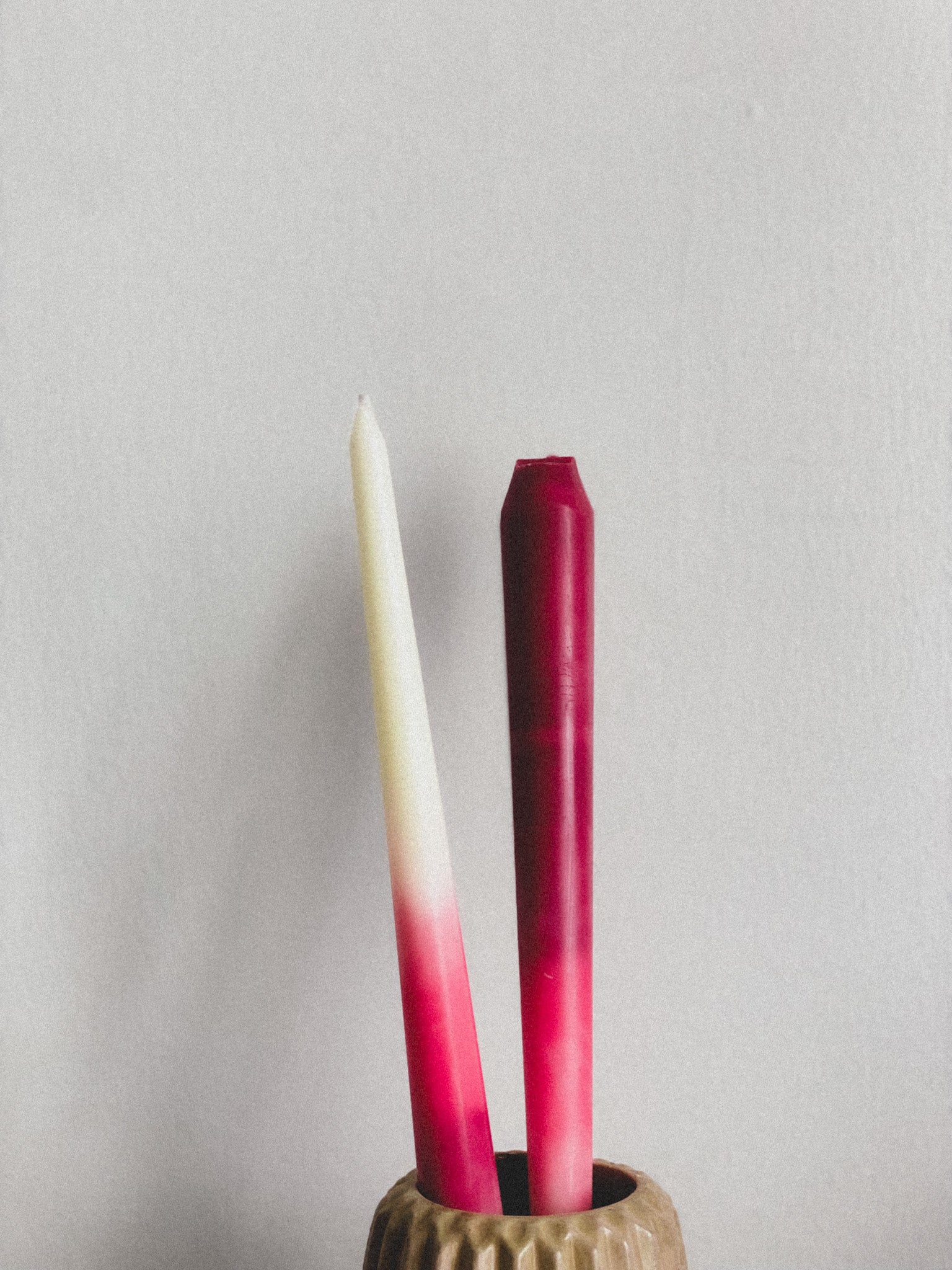 Two gradient tapers in a holder against a plain background
