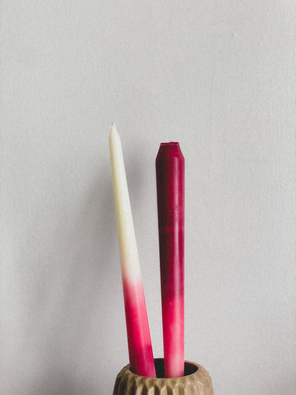 Two gradient tapers in a holder against a plain background